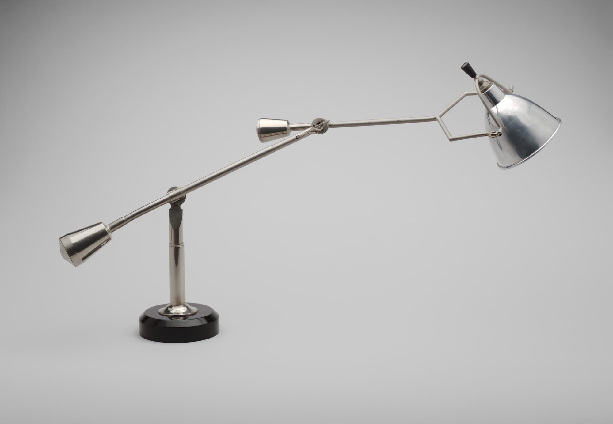 A desk lamp designed by Edouard Wilfrid Buquet in 1925. It features a double-arm design and is made from nickel-plated brass, aluminium and varnished wood.